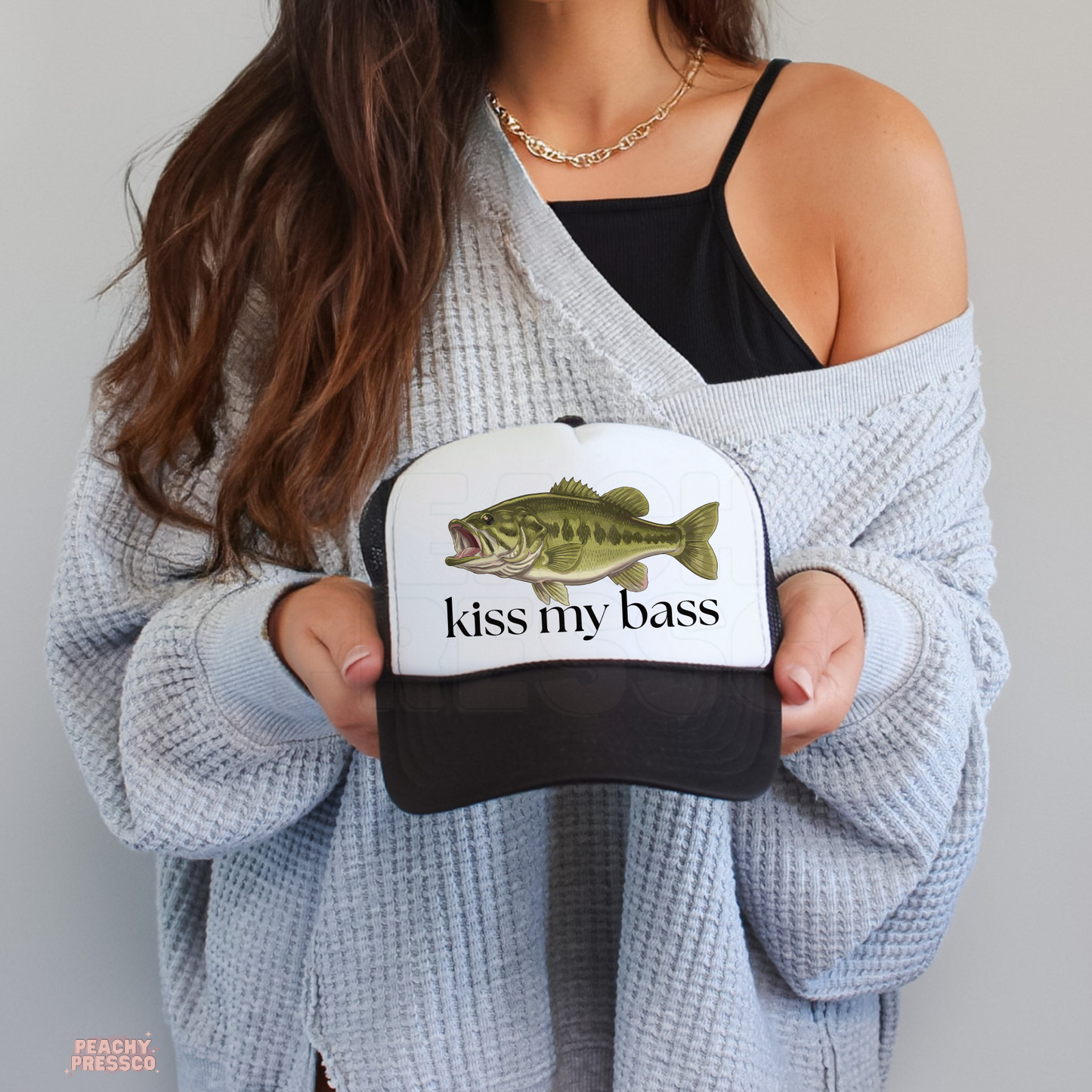 Black and white trucker hat with bass fish and Kiss My Bass text.