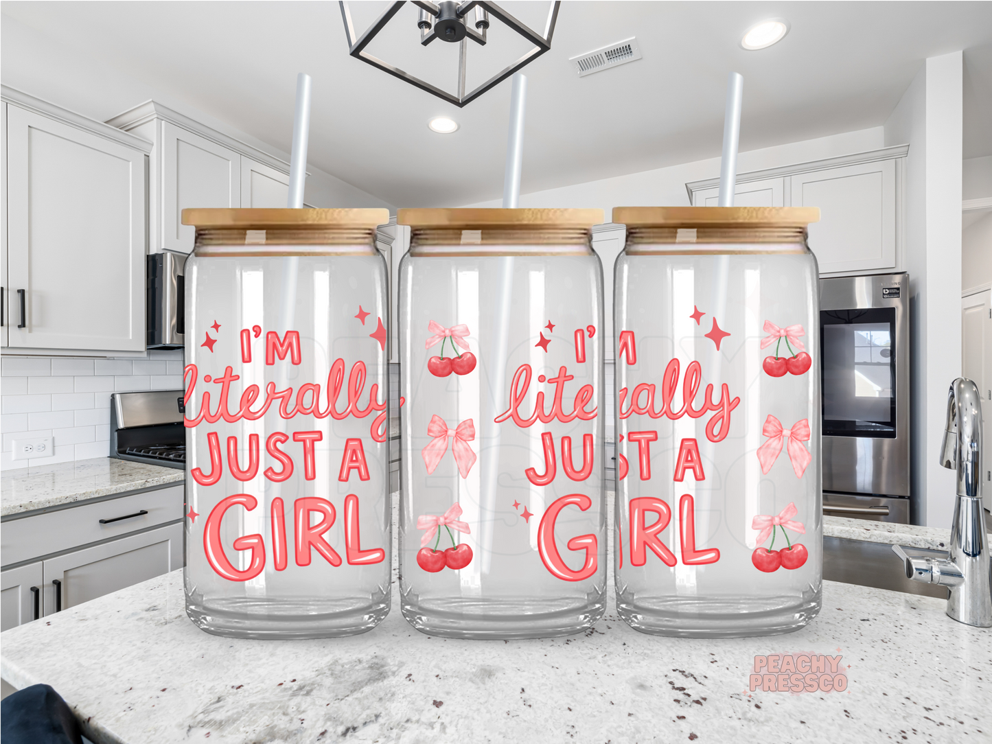 Clear glass cup with "I'm Literally Just a Girl" lettering decorated with pink cherries, bows, and sparkles for a fun coquette iced coffee aesthetic.