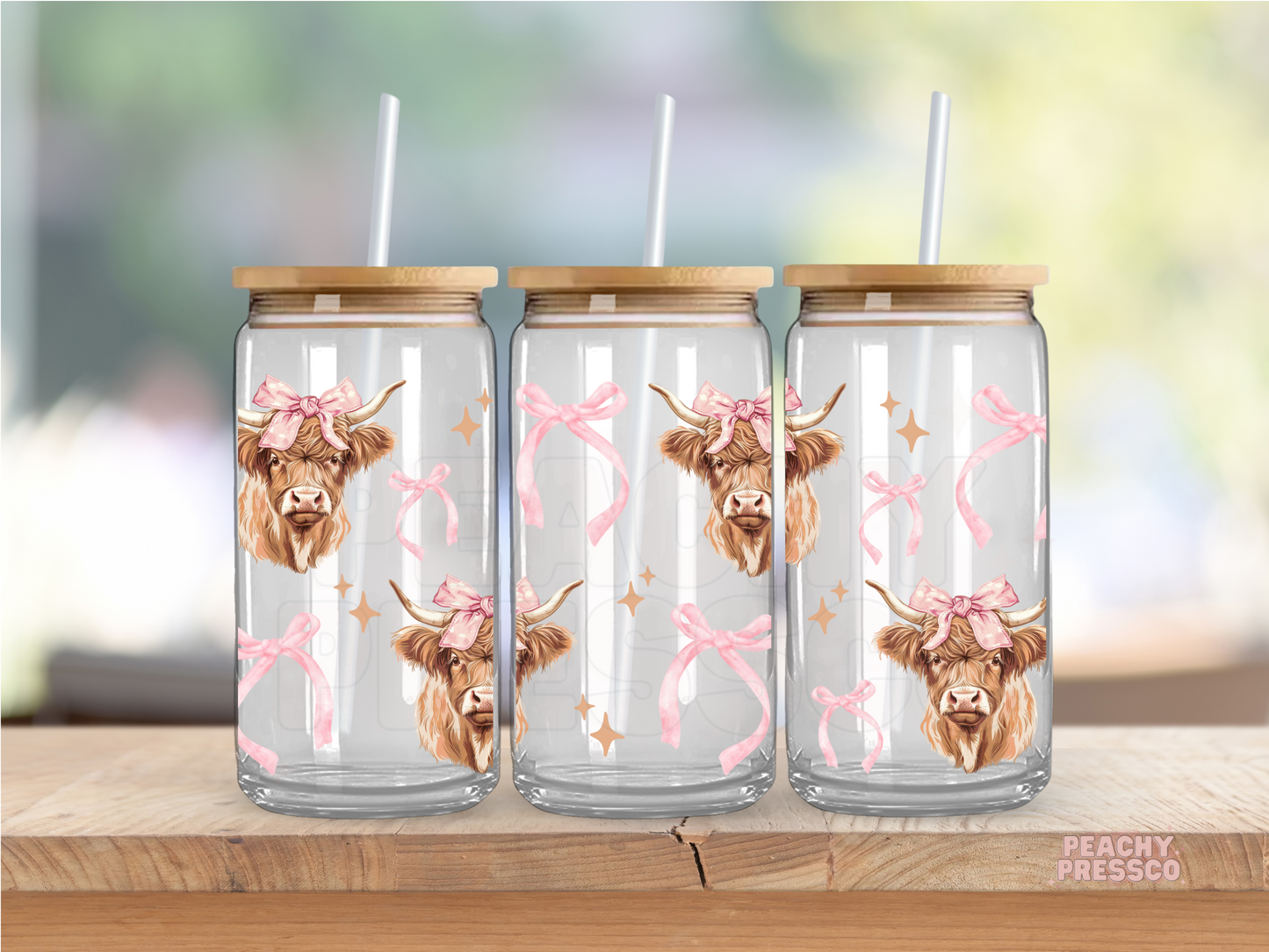 Glass can decorated with repeating Highland cow faces wearing pink bows alongside pink ribbon accents.