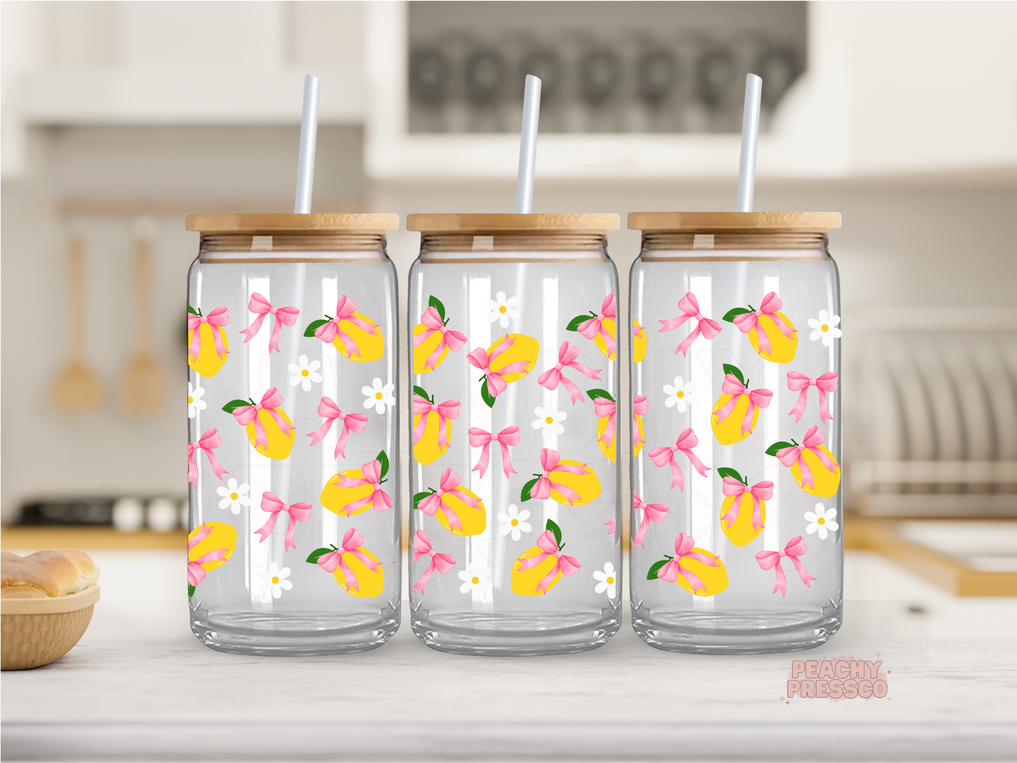 16 oz glass cup featuring bright lemons tied with pink bows, white daisies, and a cheerful repeating pattern with a bamboo lid and glass straw.