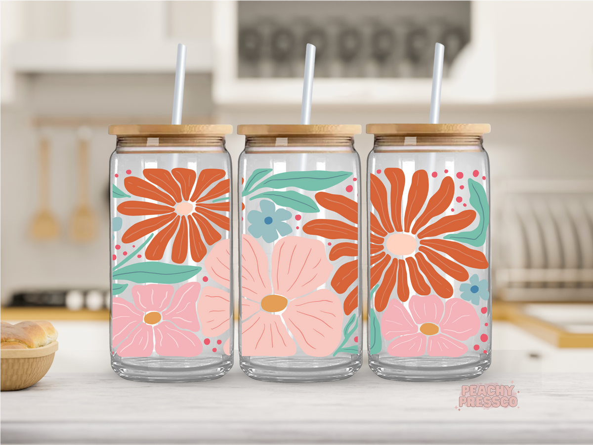 16 oz clear glass cup featuring oversized retro flowers in coral, blush, teal, and orange with playful botanical accents. Includes bamboo lid and reusable straw.