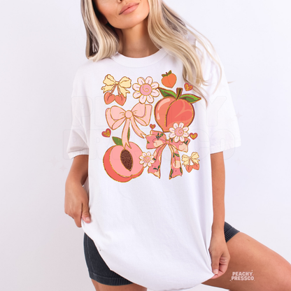 Woman wearing a white oversized t-shirt with pastel peach, flower, and ribbon graphic design.