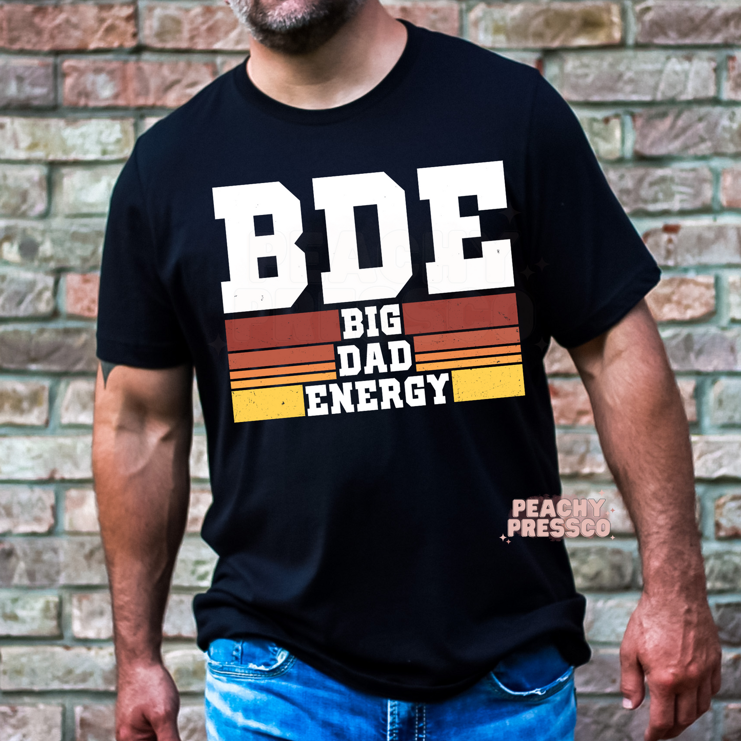 Man wearing black t-shirt with bold white “BDE Big Dad Energy” vintage-inspired graphic design.