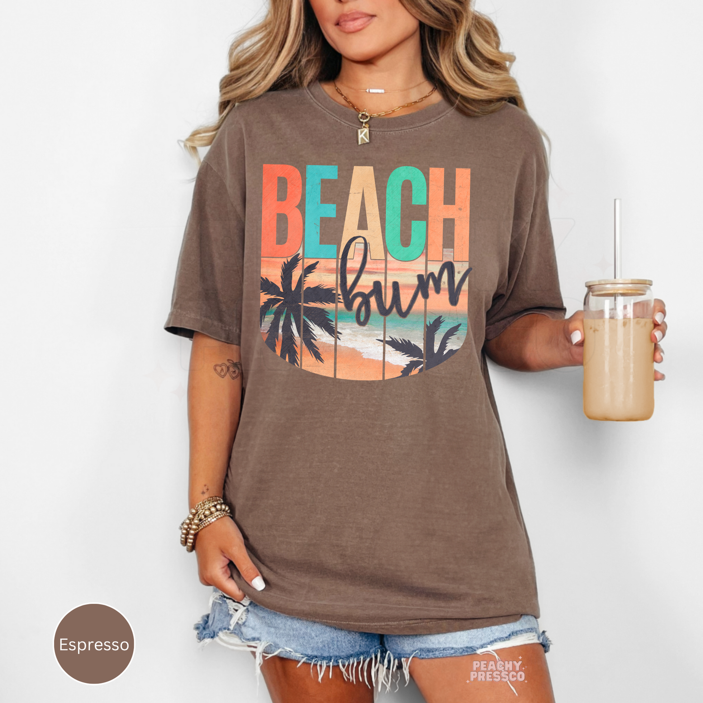 Woman wearing an espresso brown Beach Bum vintage oversized t-shirt with retro coastal sunset graphic design.