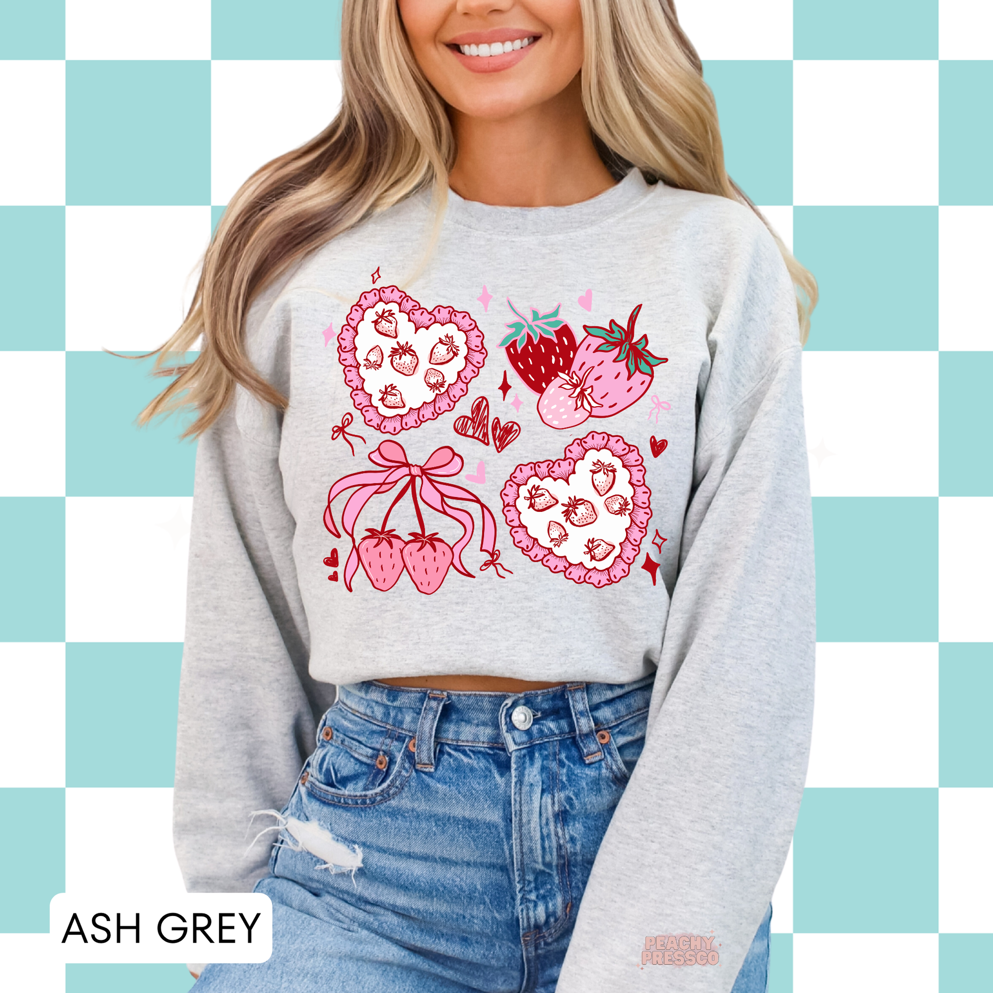 Woman wearing ash grey crewneck sweatshirt with cute pink strawberry hearts, bows, and coquette-inspired graphic design.