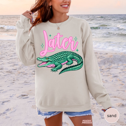 Sand crewneck sweatshirt featuring a retro pink “Later” graphic with teal alligator illustration – cute southern lake life sweatshirt for women.