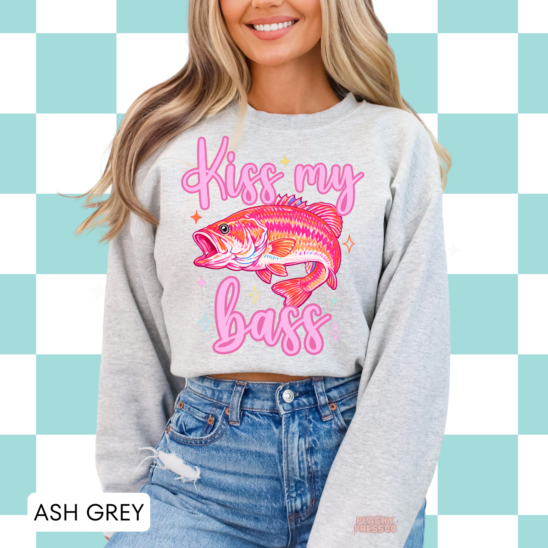 Ash grey crewneck sweatshirt featuring a colorful pink bass fish graphic with “Kiss My Bass” text in retro script – funny women’s fishing apparel, lake life sweatshirt.