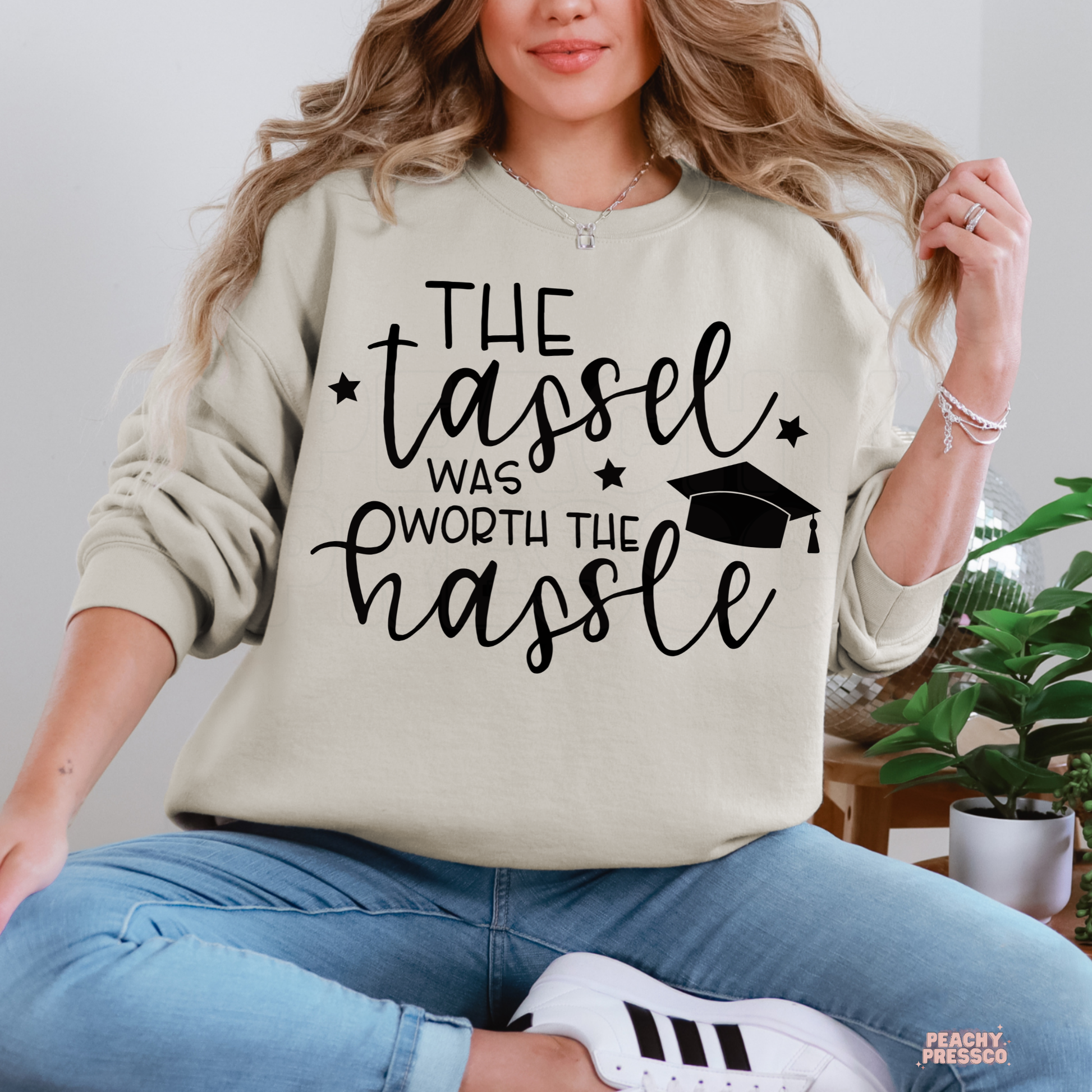 Graduation crewneck with motivational tassel quote and graduation cap illustration, perfect gift for high school or college graduates.