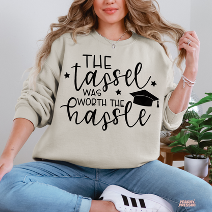 Graduation crewneck with motivational tassel quote and graduation cap illustration, perfect gift for high school or college graduates.