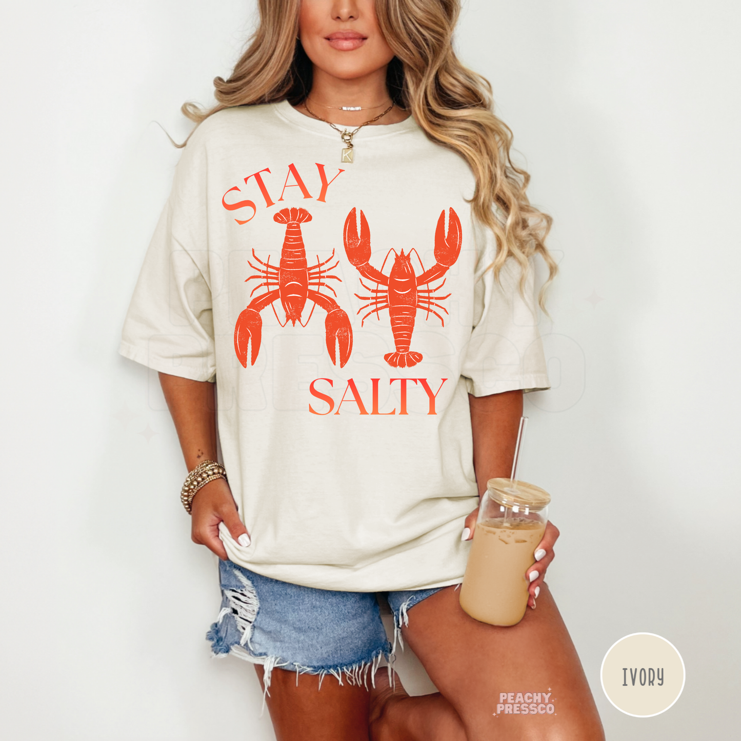 Ivory oversized graphic t-shirt featuring vintage lobster artwork and “Stay Salty” text – coastal vacation shirt for women.