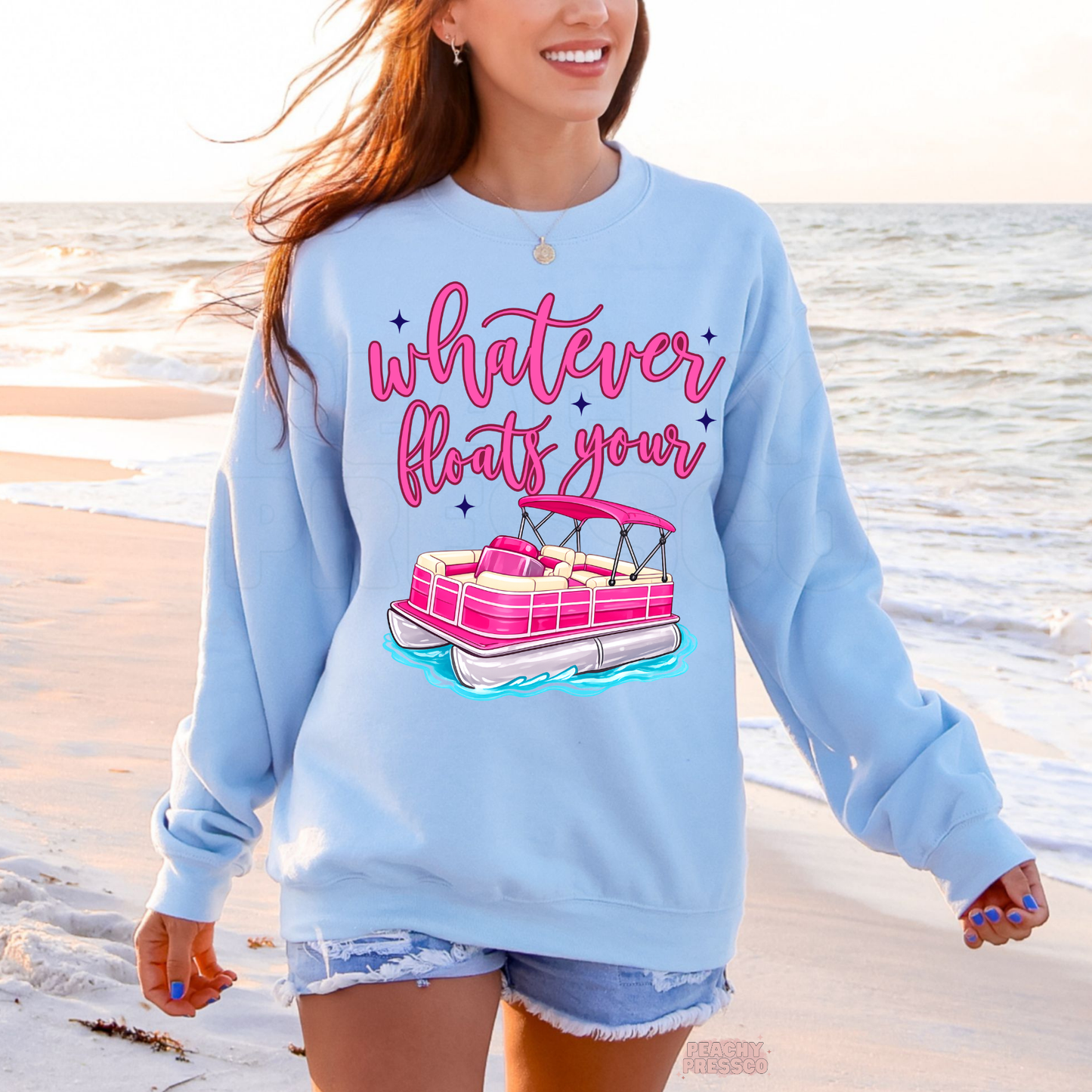 Light blue crewneck featuring hot pink pontoon boat artwork and “Whatever Floats Your” graphic – cozy coastal and boating sweatshirt.