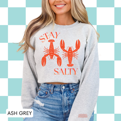 Ash grey crewneck sweatshirt with retro lobster illustration and “Stay Salty” graphic – relaxed coastal style sweatshirt for women.