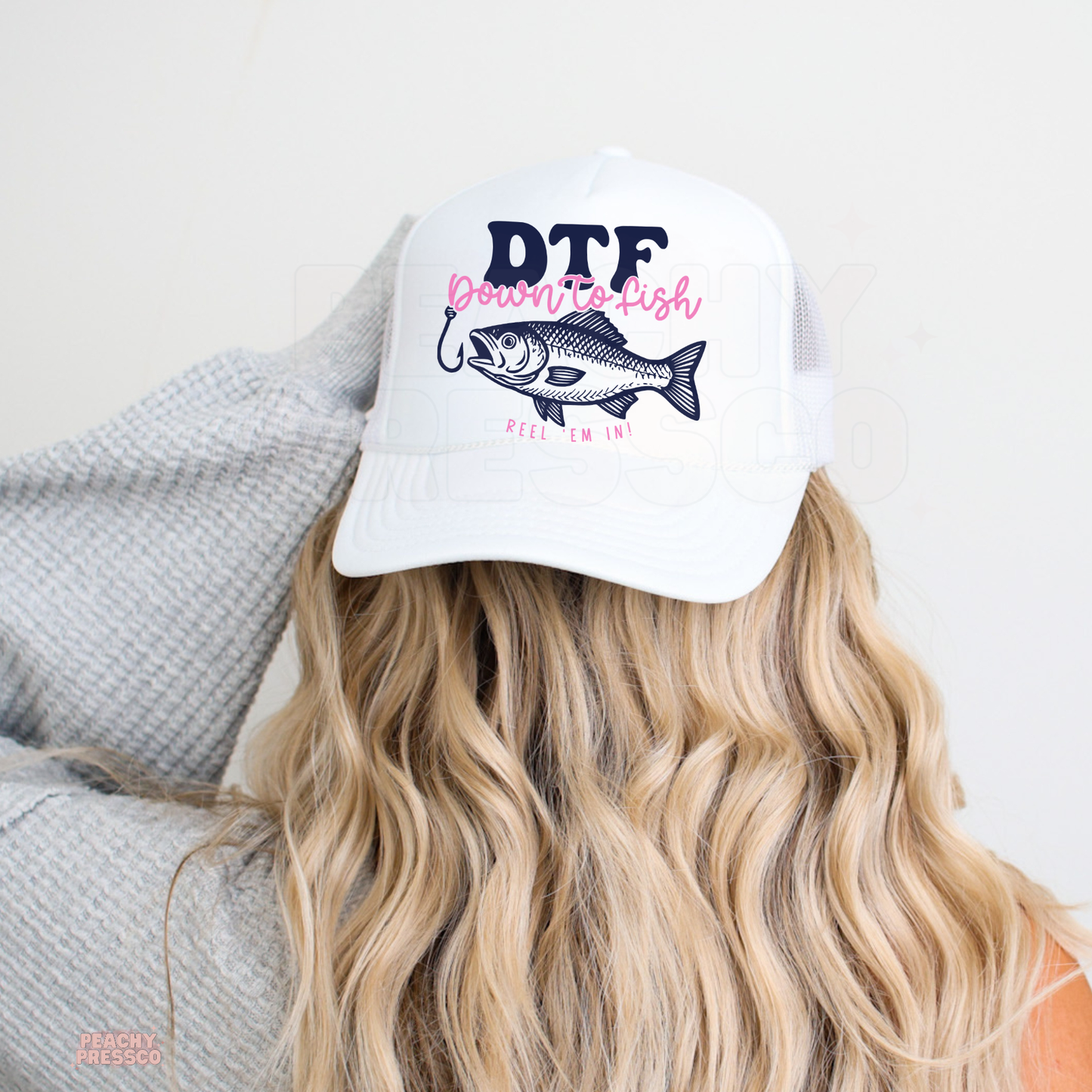Women’s white fishing trucker hat with Down To Fish bass graphic in pink and navy for boating, camping and outdoor adventures.