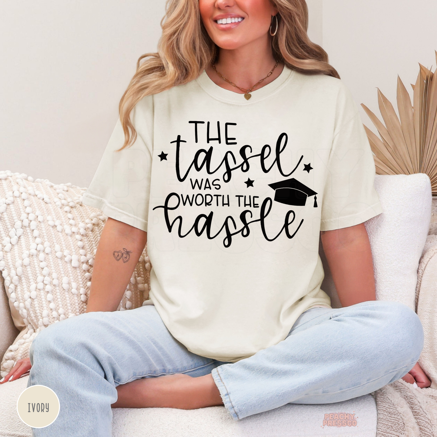 Ivory graduate t-shirt featuring The Tassel Was Worth the Hassle phrase and graduation cap artwork for graduation season.