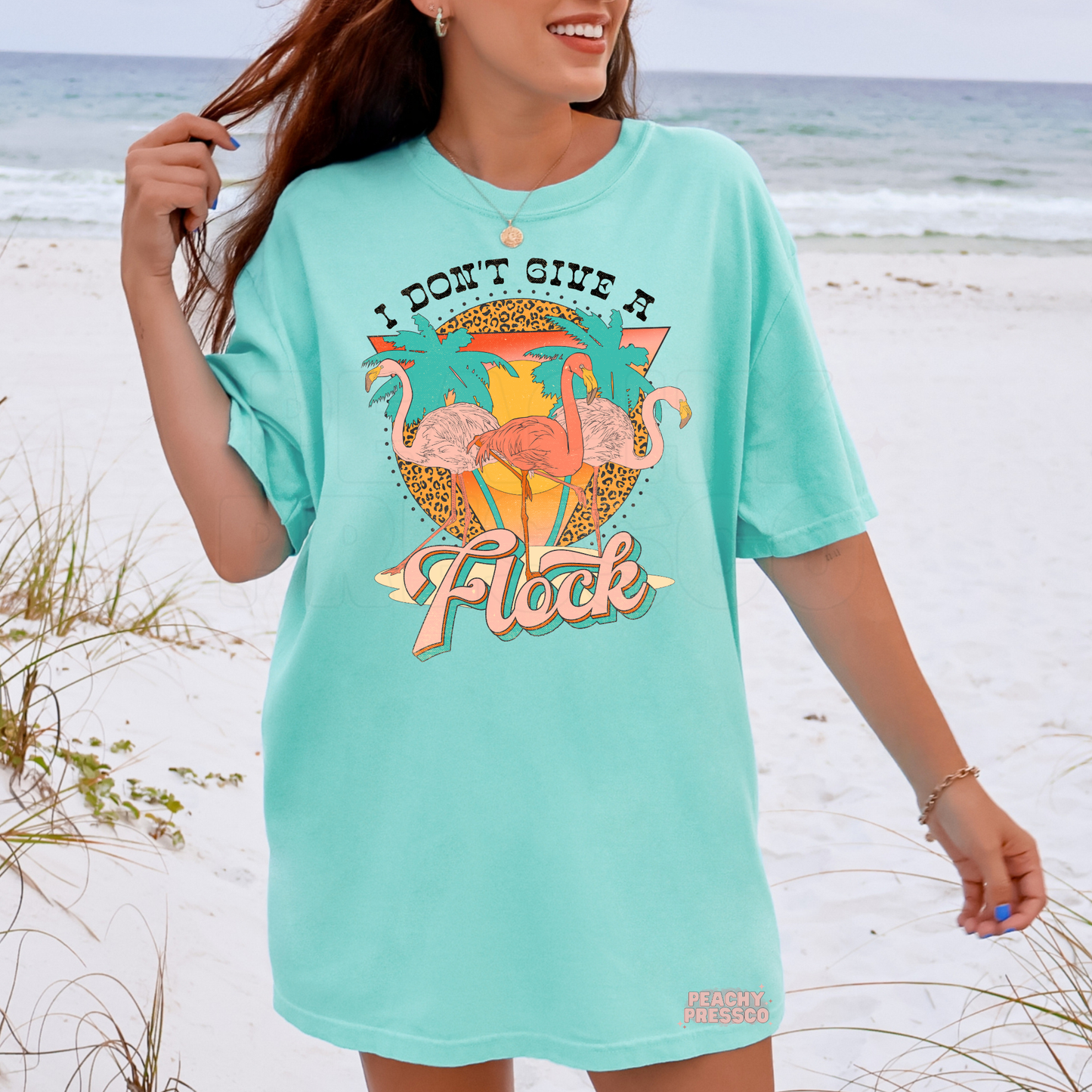 Woman wearing an island reef oversized beach t-shirt with vibrant flamingo graphic and tropical summer design.
