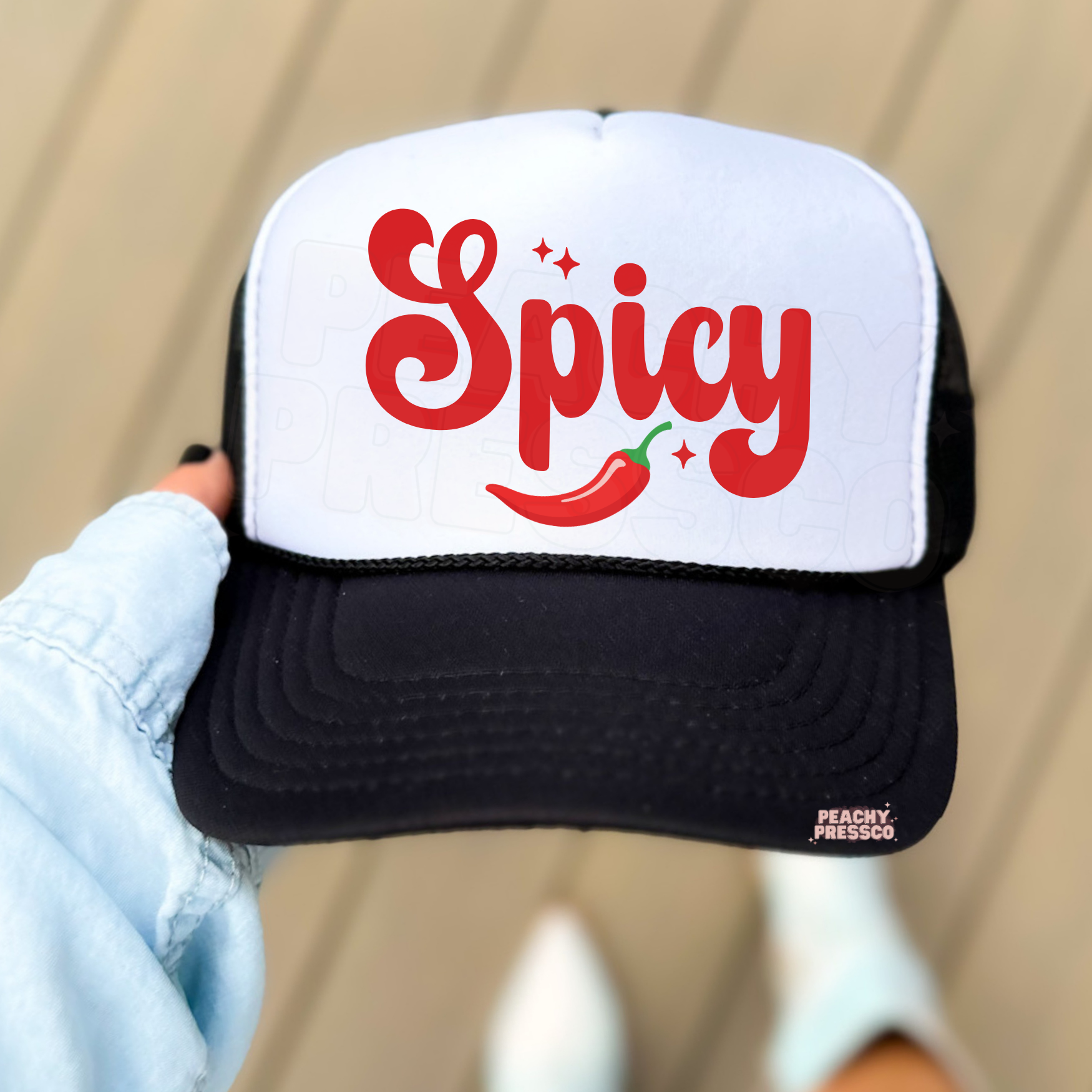 White and black trucker hat featuring red “Spicy” typography with chili pepper.
