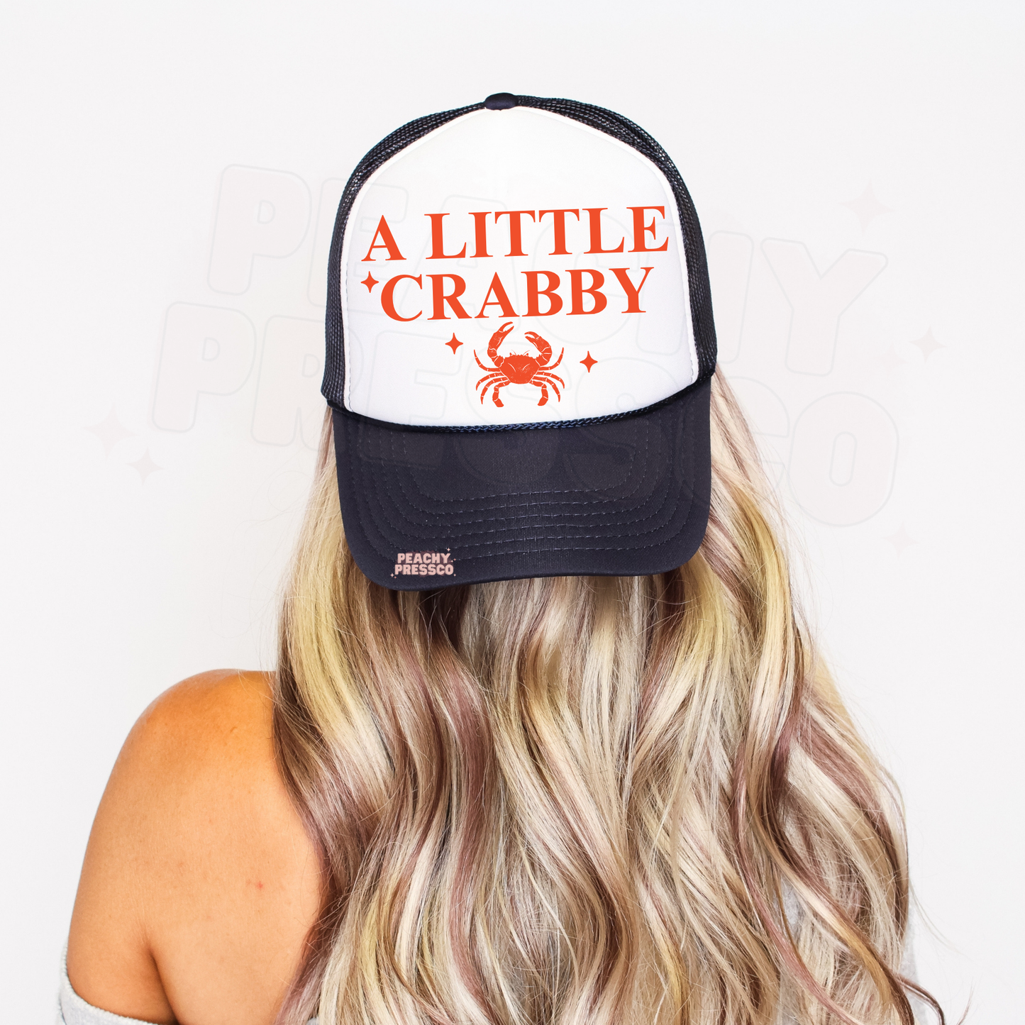 Navy trucker hat with A Little Crabby coastal graphic and crab illustration – stylish summer hat for beach lovers and boating days.