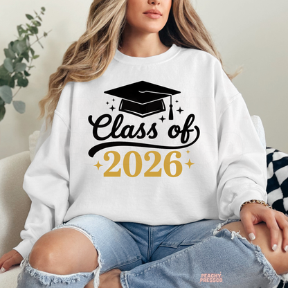 Woman wearing white Class of 2026 graduation sweatshirt featuring black script lettering and graduation cap graphic.