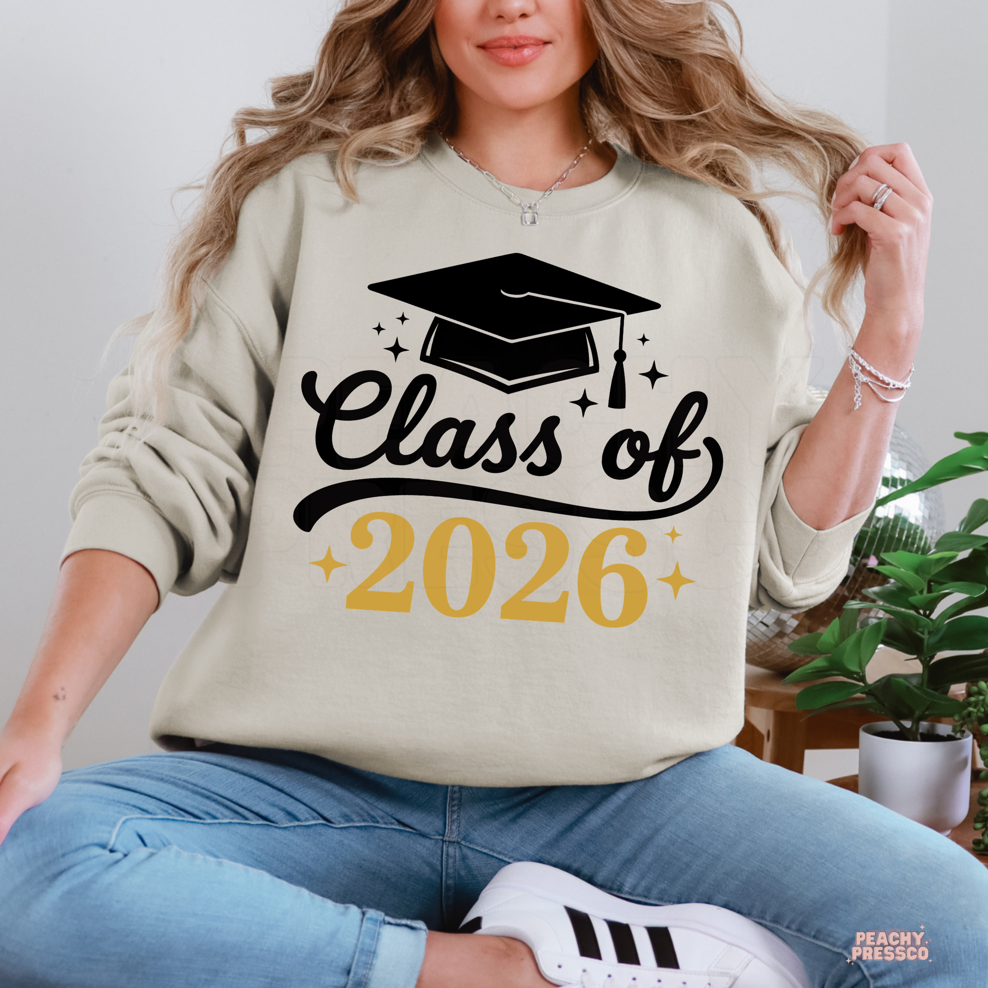 Class of 2026 crewneck sweatshirt in sand featuring graduation cap graphic and elegant gold lettering for high school graduates.