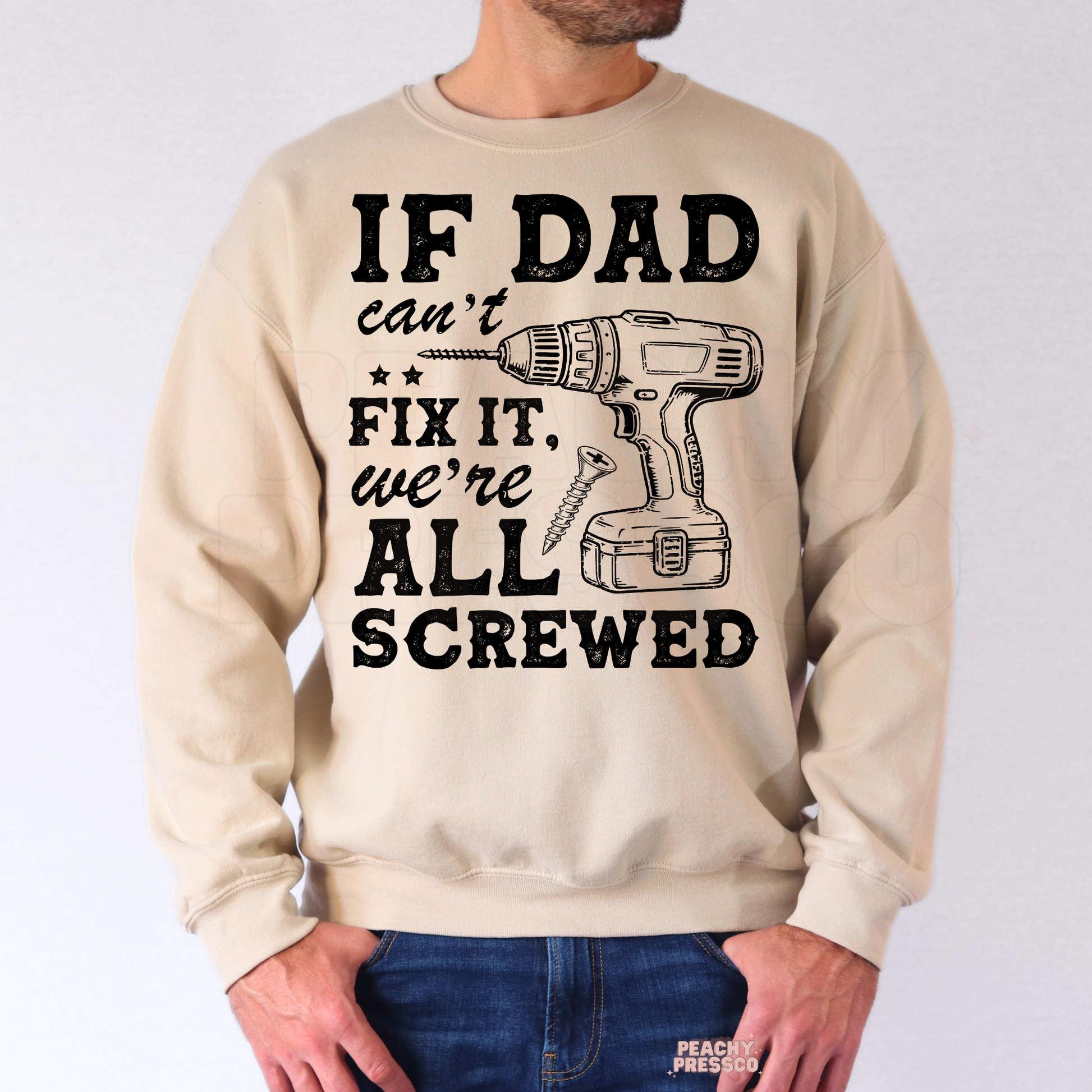 Man wearing beige crewneck sweatshirt with humorous repair-themed dad graphic and vintage style typography.