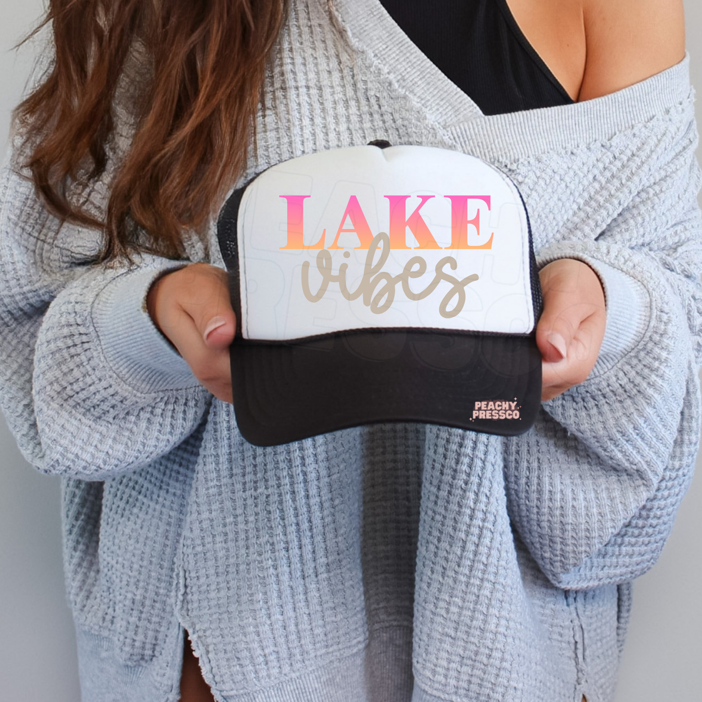 Black and white trucker hat featuring Lake Vibes typography.
