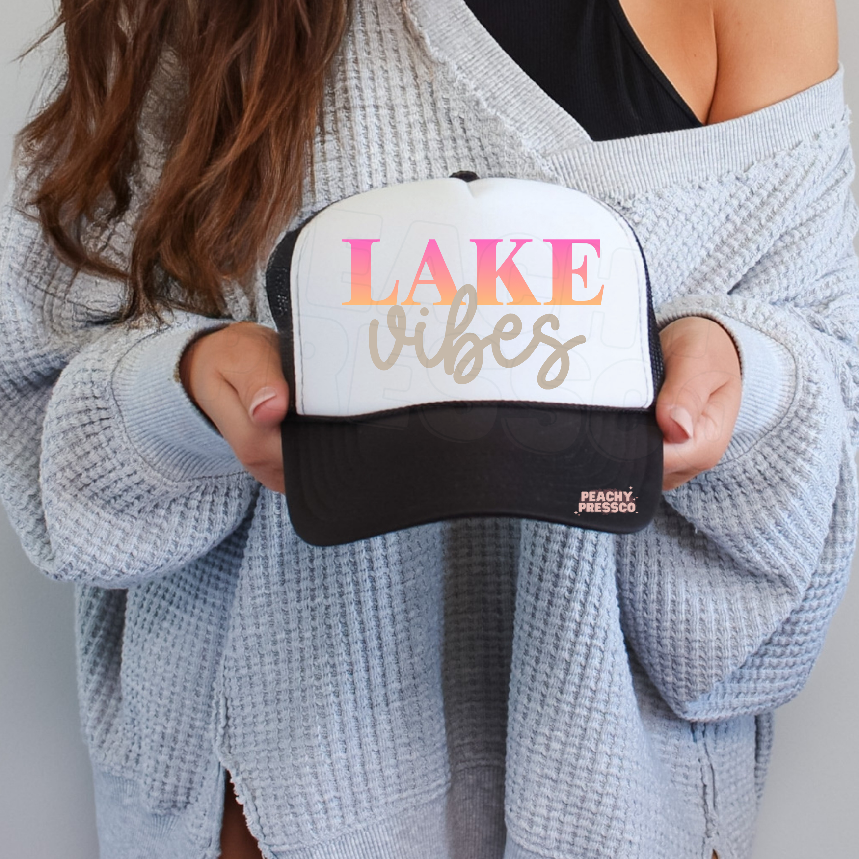 Black and white trucker hat featuring Lake Vibes typography.
