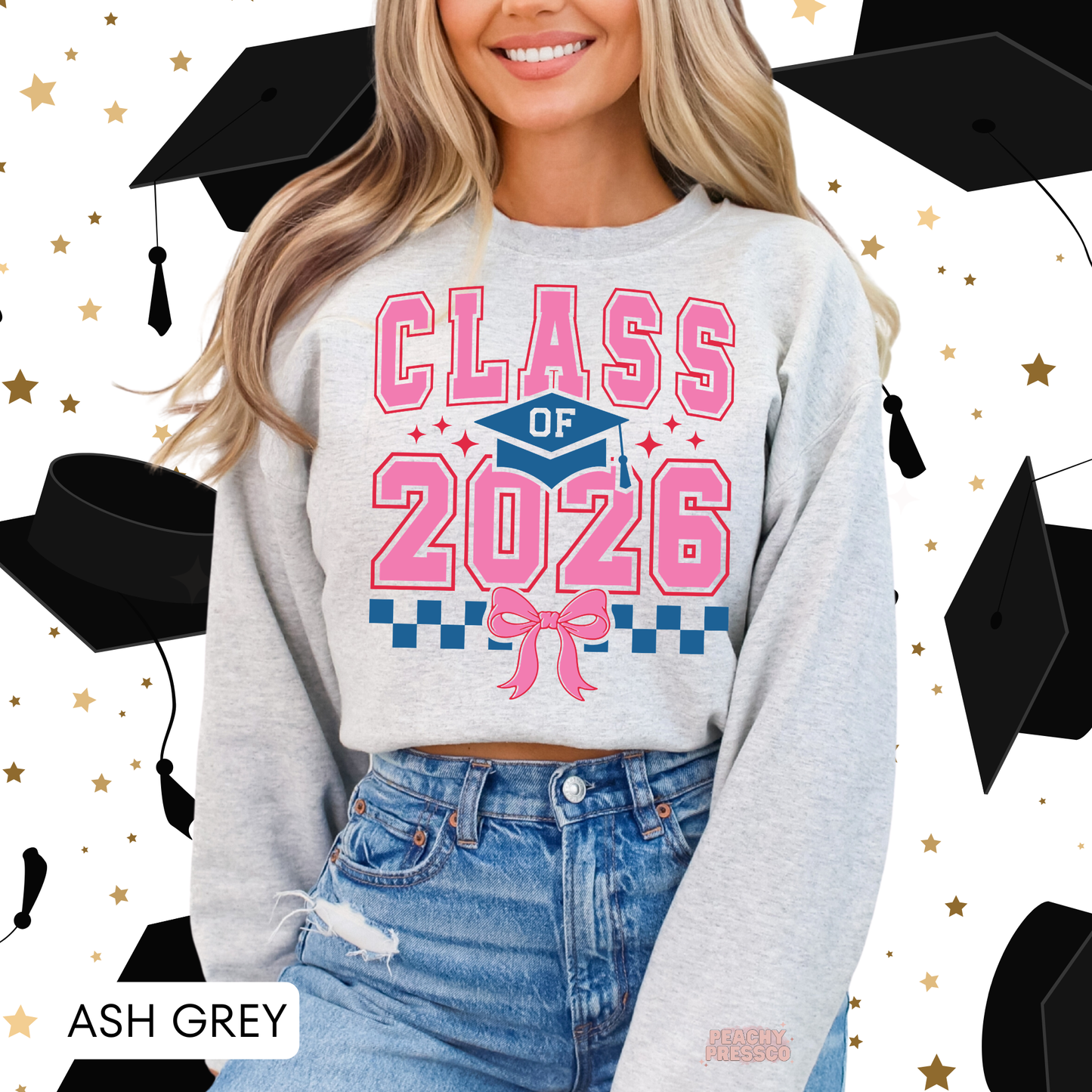 Trendy Class of 2026 graduation sweatshirt featuring pink varsity text, graduation cap, bow detail design.