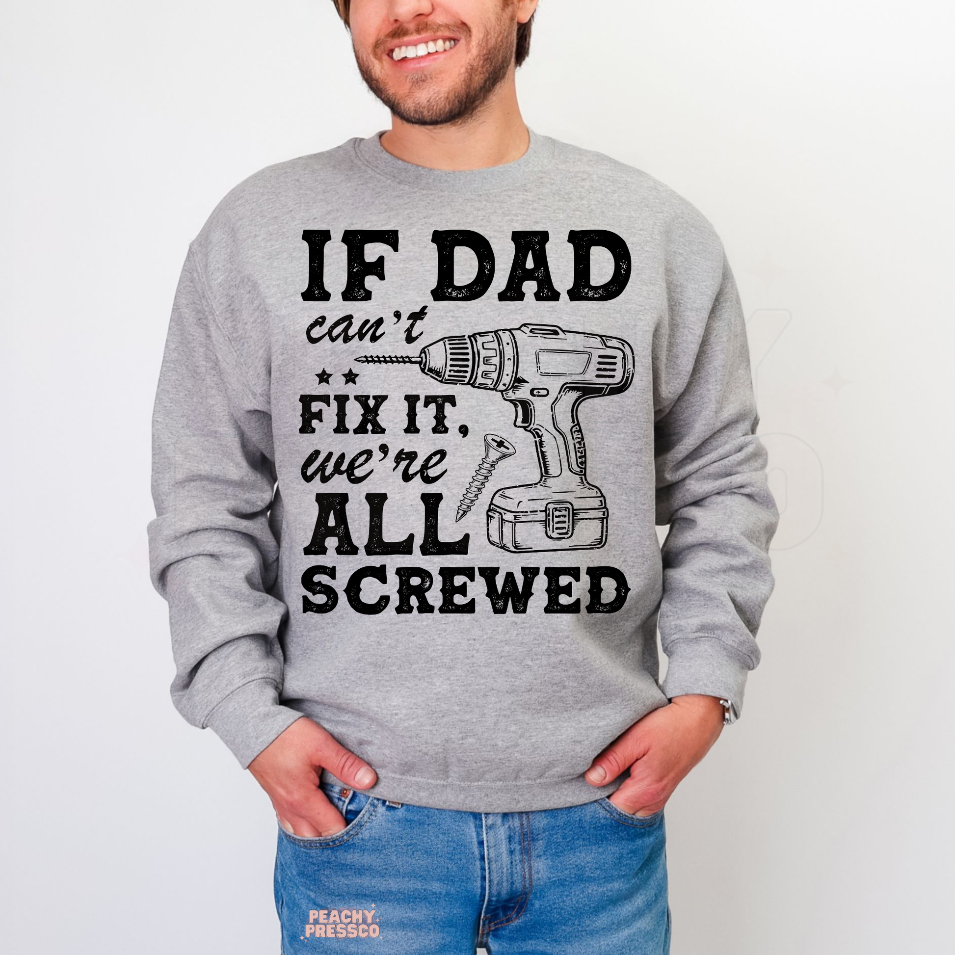 Man wearing grey crewneck sweatshirt with distressed black dad repair graphic and drill illustration.