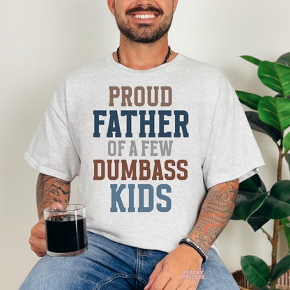 Man modeling ash grey t-shirt featuring colorful “Proud Father of a Few Dumbass Kids” Father’s Day typography print.