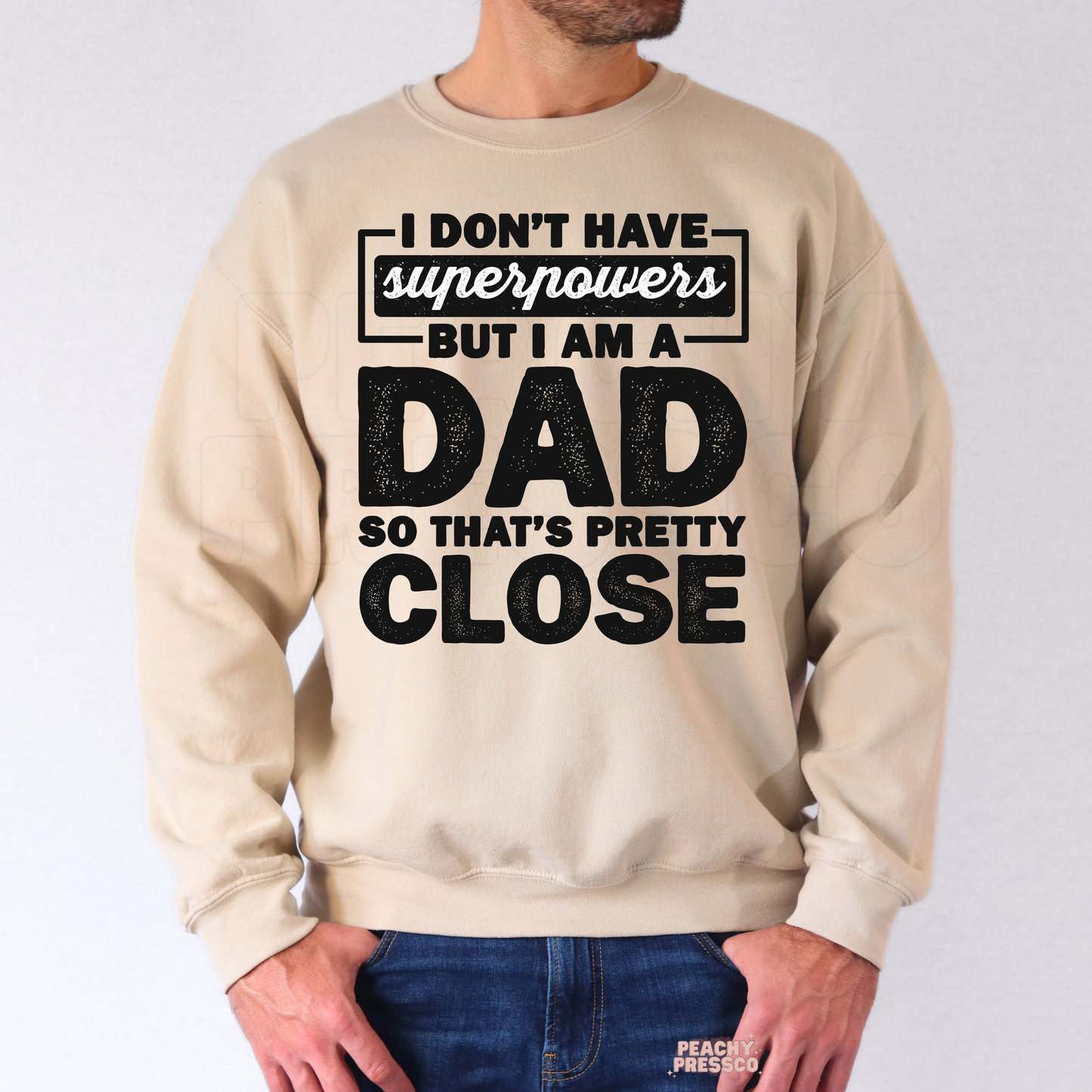 Man wearing beige crewneck sweatshirt with humorous dad quote graphic in distressed black lettering.
