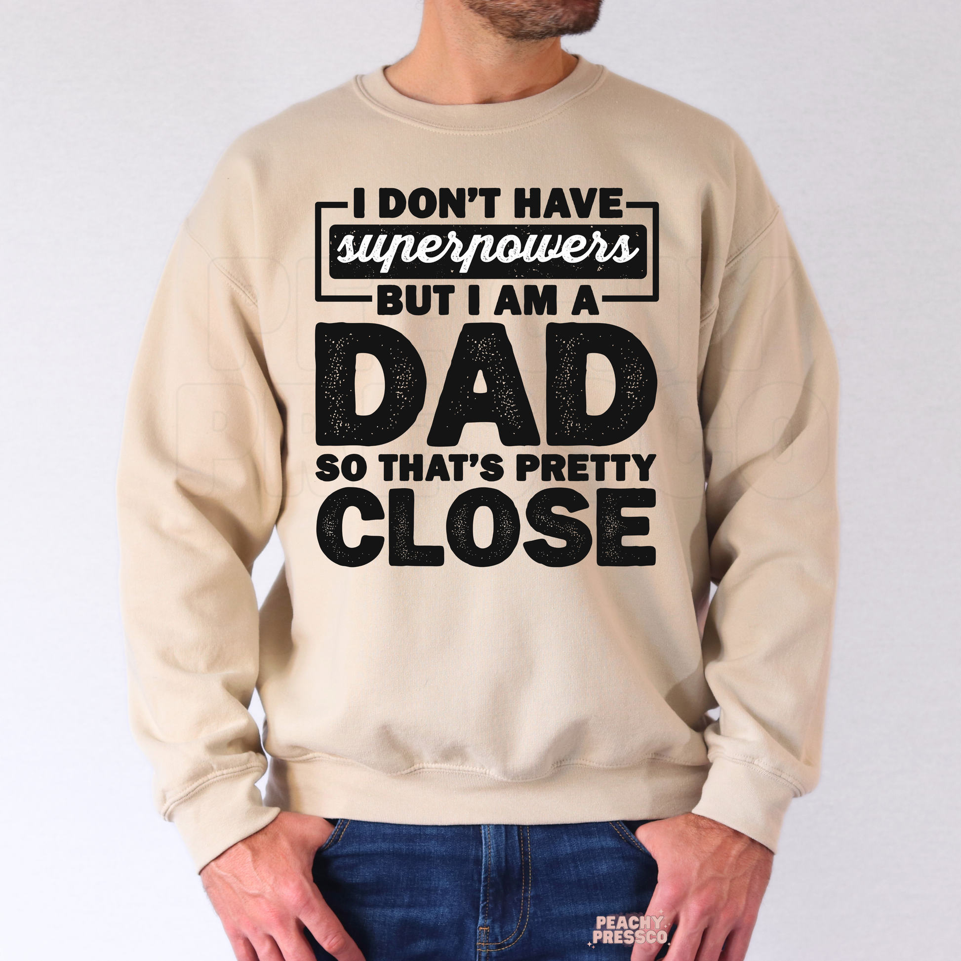 Man wearing beige crewneck sweatshirt with humorous dad quote graphic in distressed black lettering.
