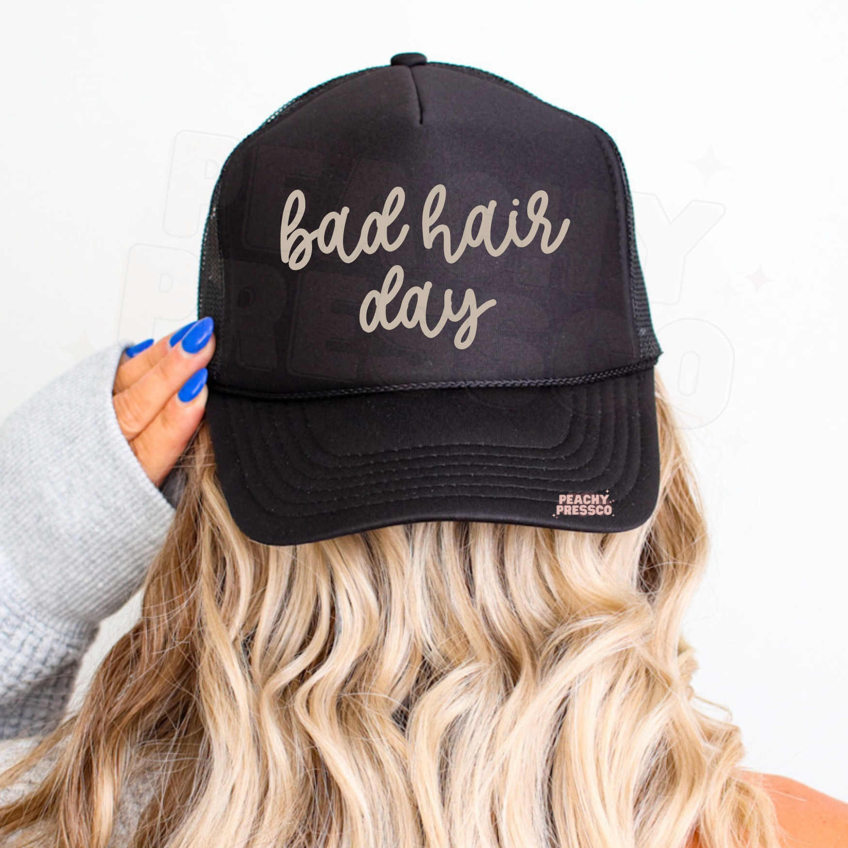 Black trucker hat featuring handwritten “Bad Hair Day” graphic.