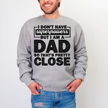 Smiling man in grey crewneck sweatshirt with funny fatherhood quote design and oversized bold typography print.