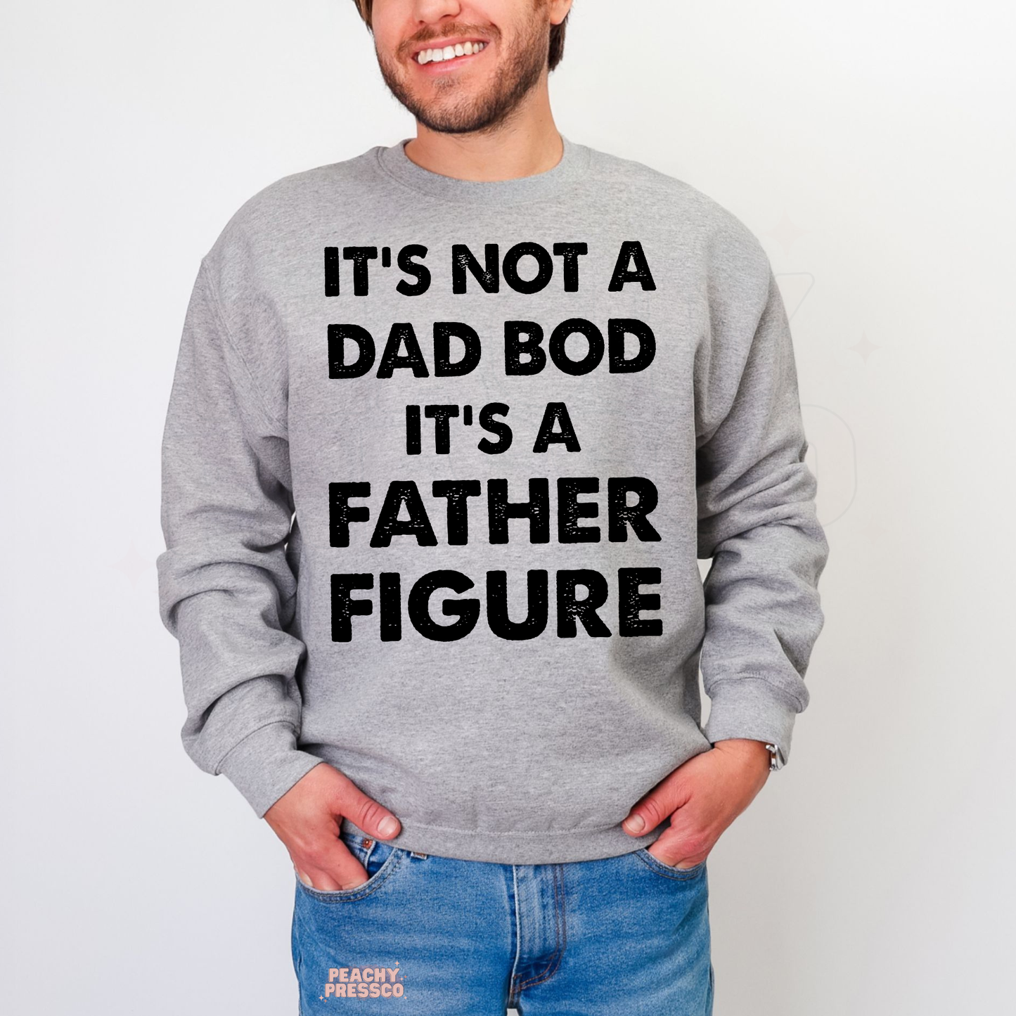 Man wearing grey crewneck sweatshirt with funny “It’s Not a Dad Bod It’s a Father Figure” graphic text design.
