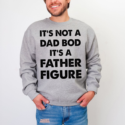 Man wearing grey crewneck sweatshirt with funny “It’s Not a Dad Bod It’s a Father Figure” graphic text design.
