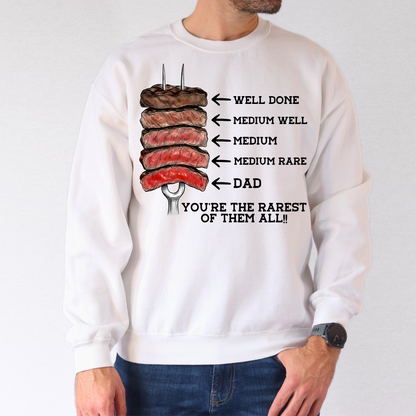 Man wearing white crewneck sweatshirt with steak doneness chart graphic and funny “Dad You’re the Rarest of Them All” Father’s Day design.