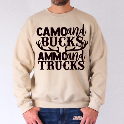 Man modeling beige crewneck sweatshirt with western hunting-inspired “Camo and Bucks Ammo and Trucks” text graphic.