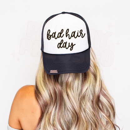 Navy and white trucker hat featuring handwritten “Bad Hair Day” graphic.