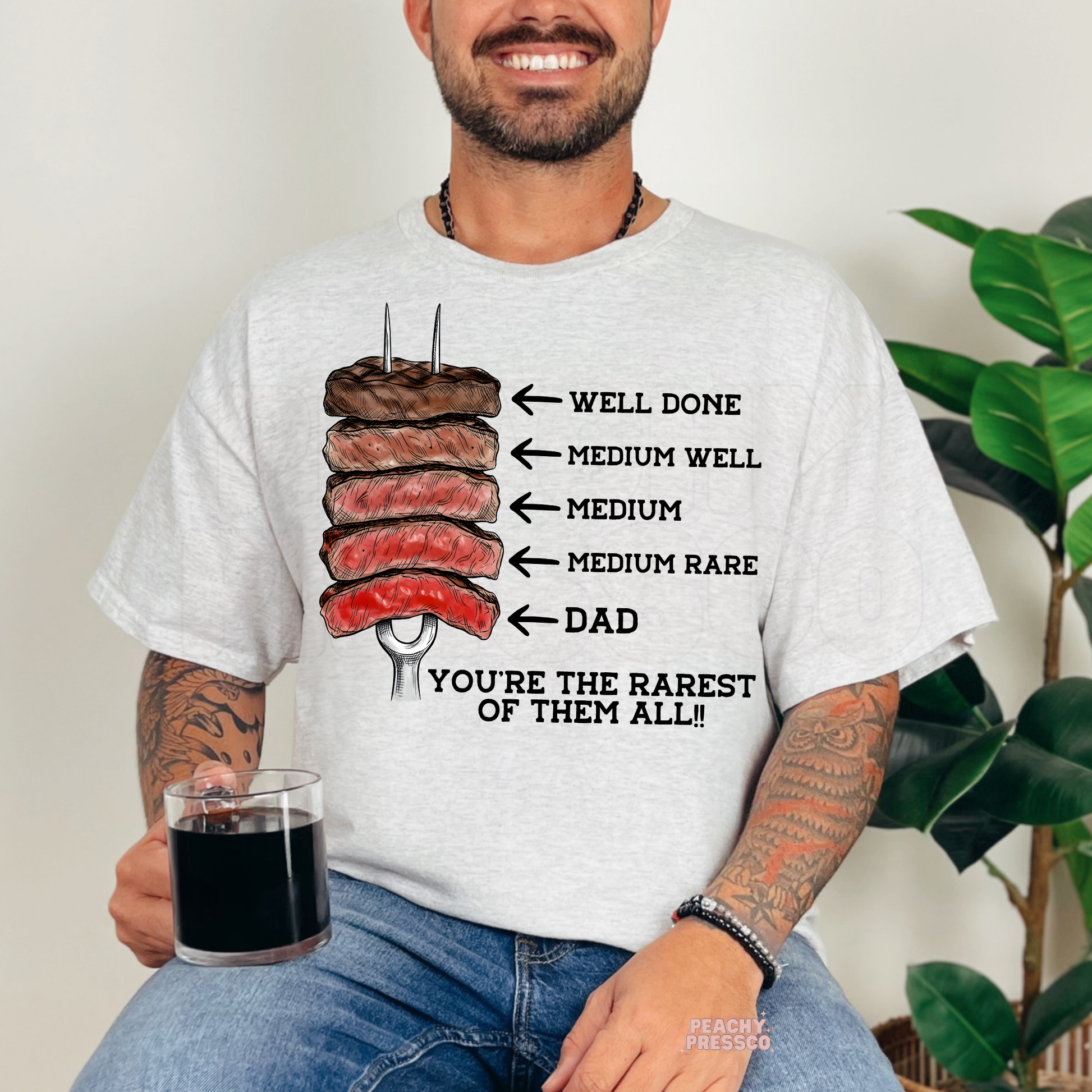 Man wearing ash grey t-shirt with steak doneness chart graphic and funny dad BBQ quote.
