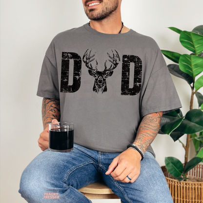 Man wearing grey t-shirt with distressed “DAD” deer antler graphic design and rustic hunting style print.
