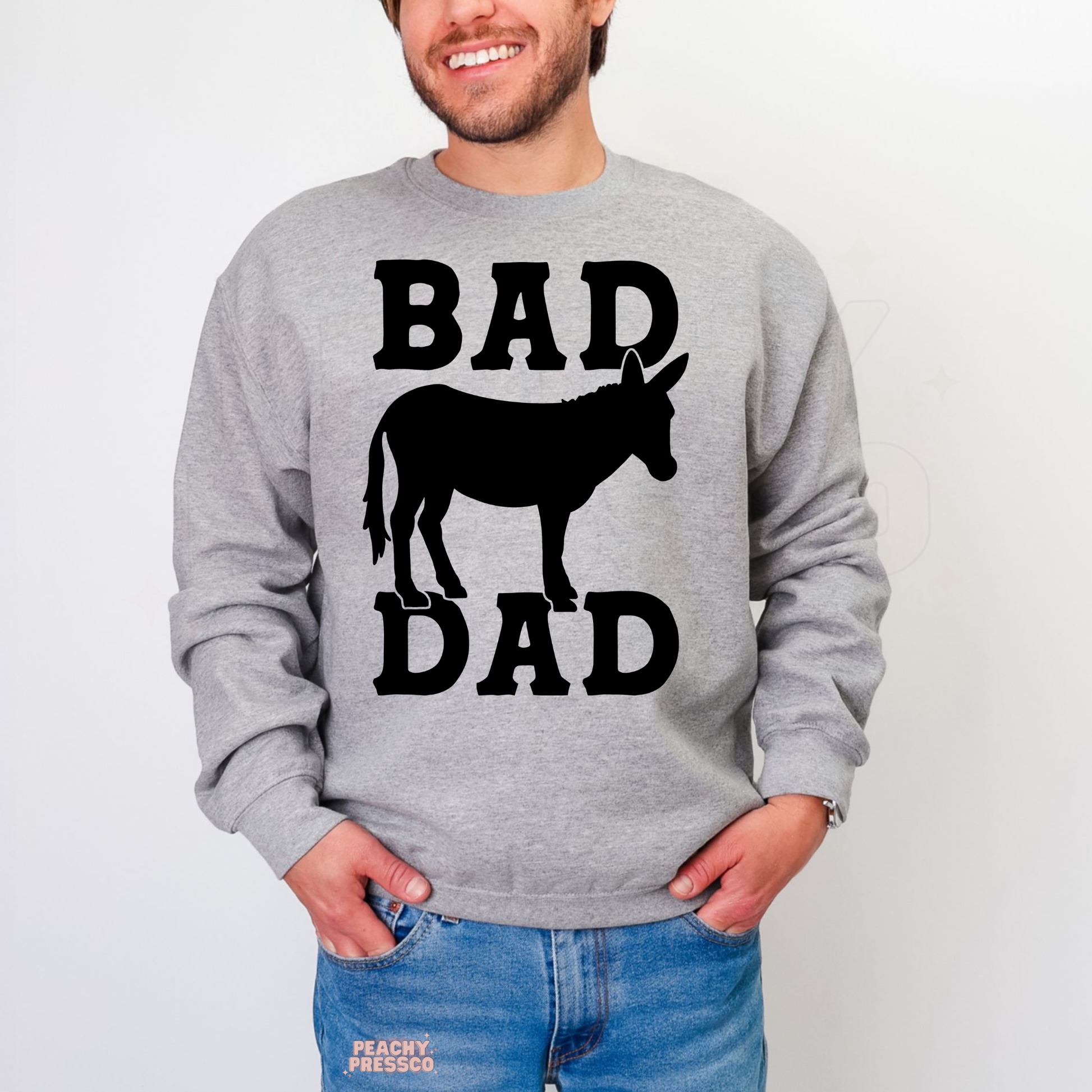 Man wearing grey crewneck sweatshirt with large “Bad Dad” donkey graphic in bold black print.