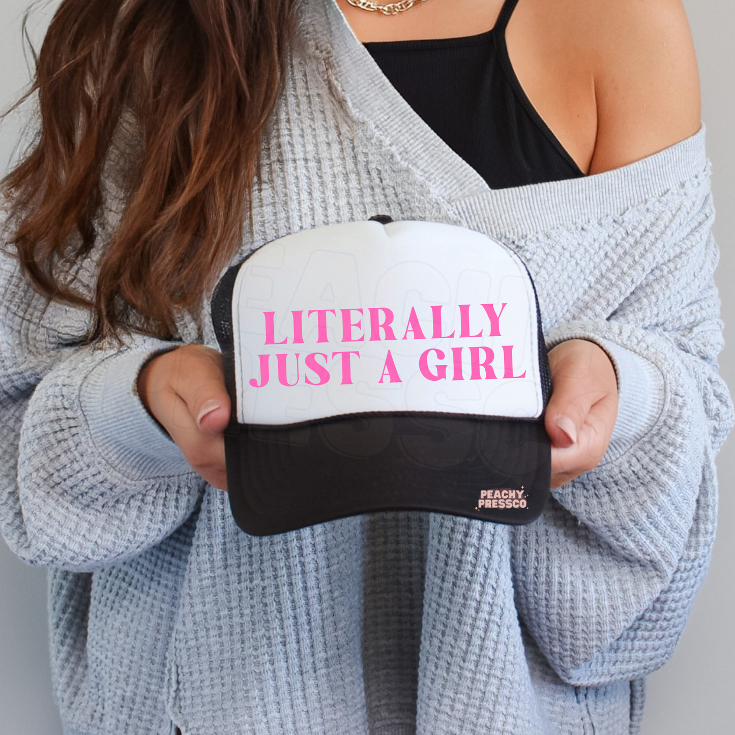Black and white trucker hat with pink “Literally Just A Girl” text.