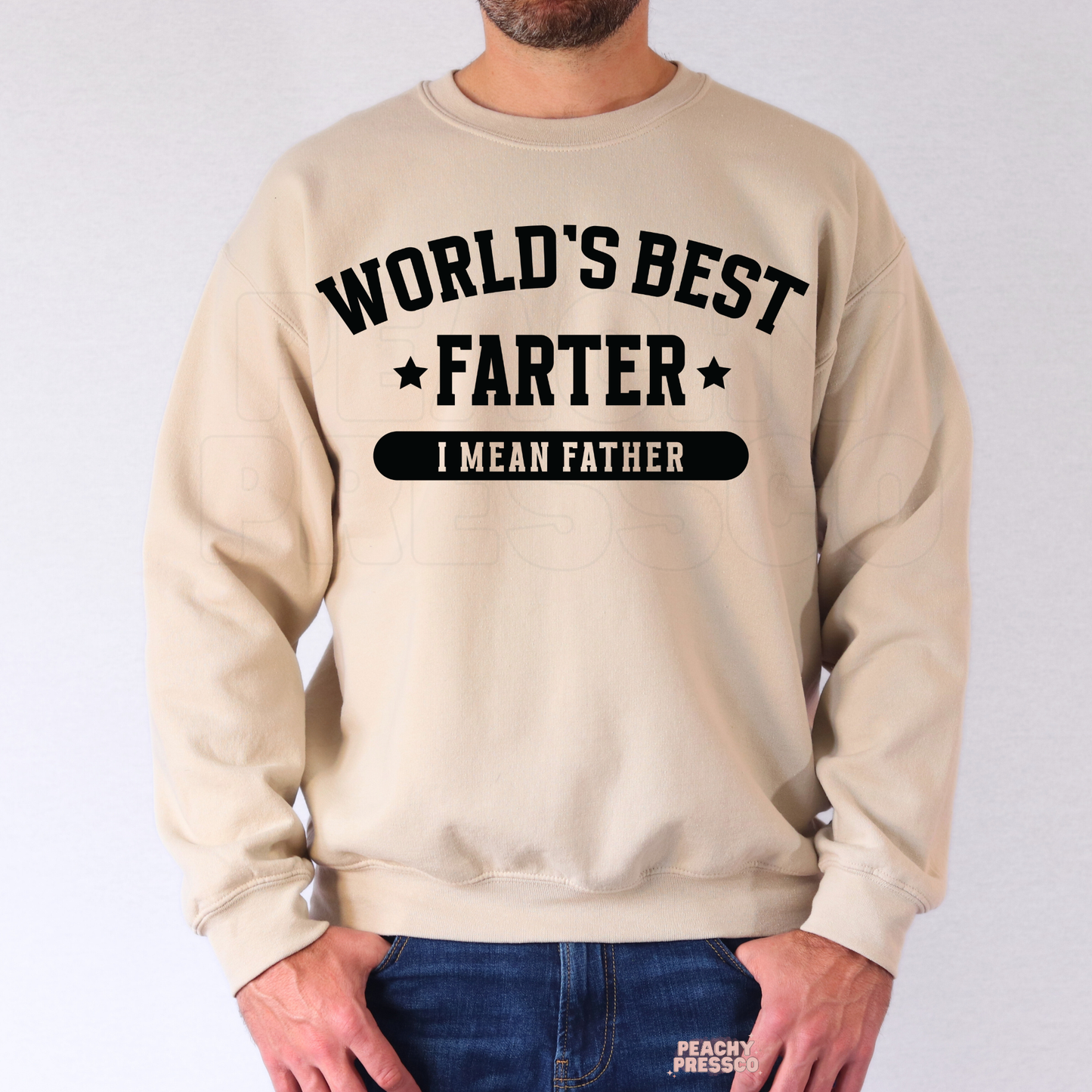 Man wearing beige crewneck sweatshirt with funny “World’s Best Farter I Mean Father” dad-themed graphic print.