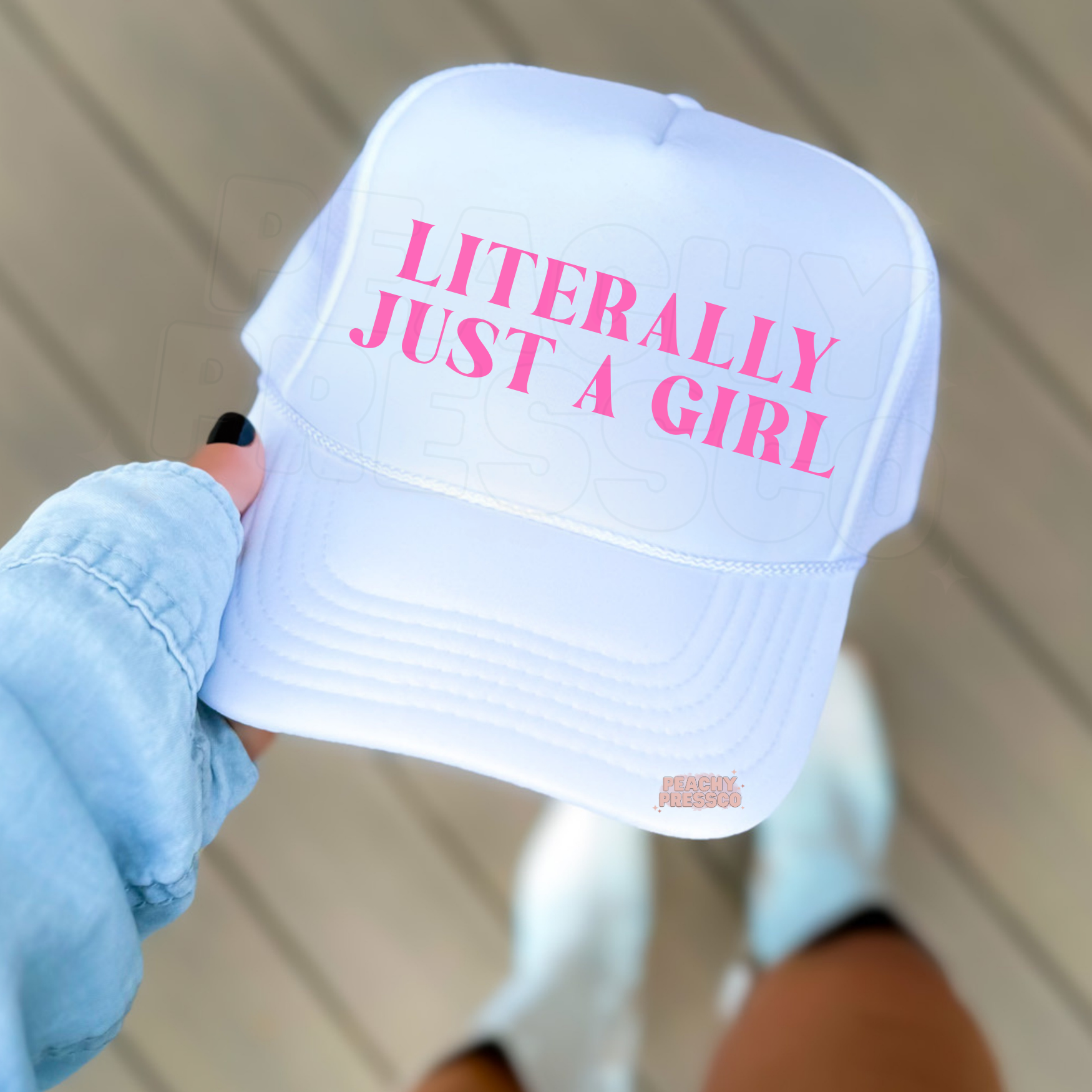 white trucker hat with pink “Literally Just A Girl” text.
