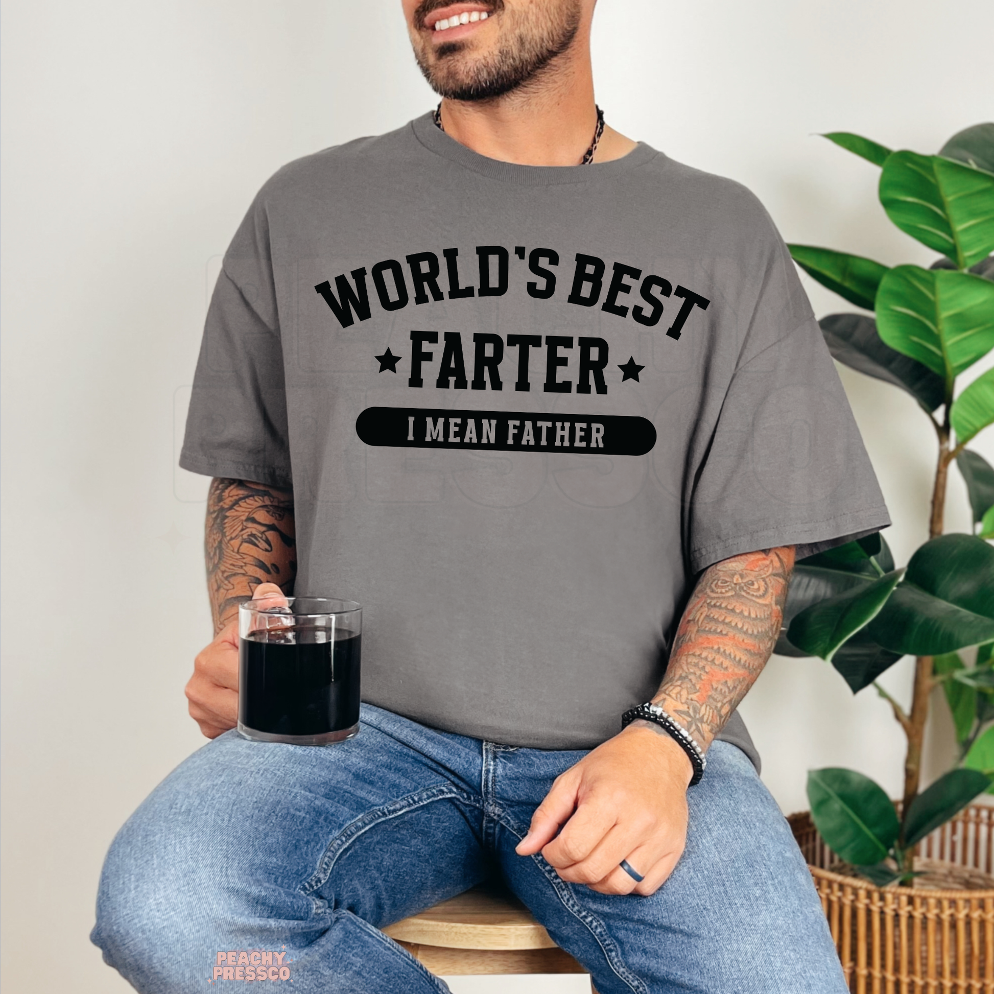 Man wearing charcoal grey t-shirt with funny “World’s Best Farter I Mean Father” graphic for Father’s Day.