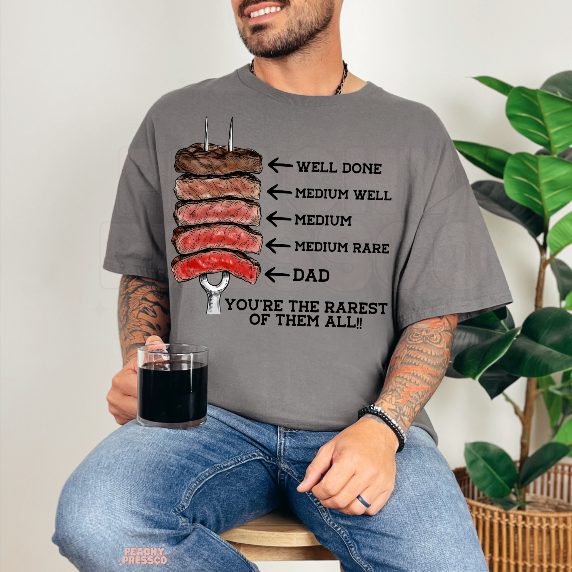 Smiling man modeling charcoal grey t-shirt featuring steak temperature chart and humorous dad grilling graphic print.