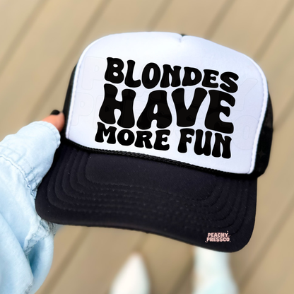 Black and white trucker hat with bold “Blondes Have More Fun” text.
