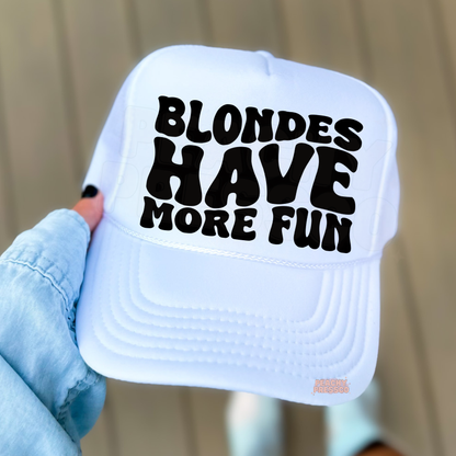 White trucker hat with bold “Blondes Have More Fun” text.
