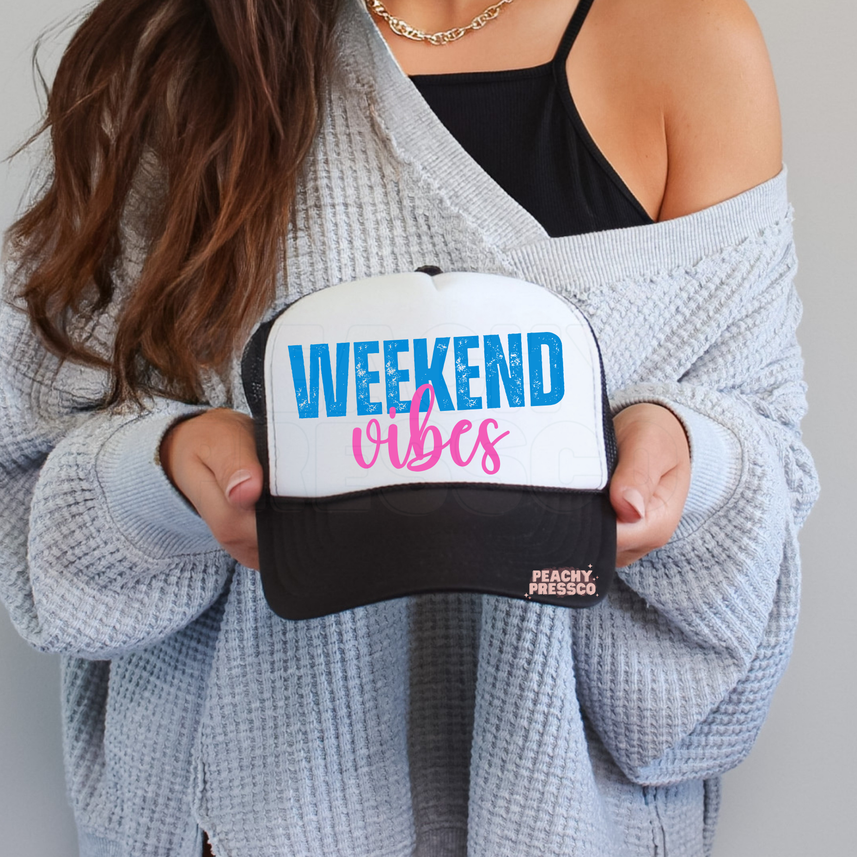Black and white trucker hat with Weekend Vibes typography.