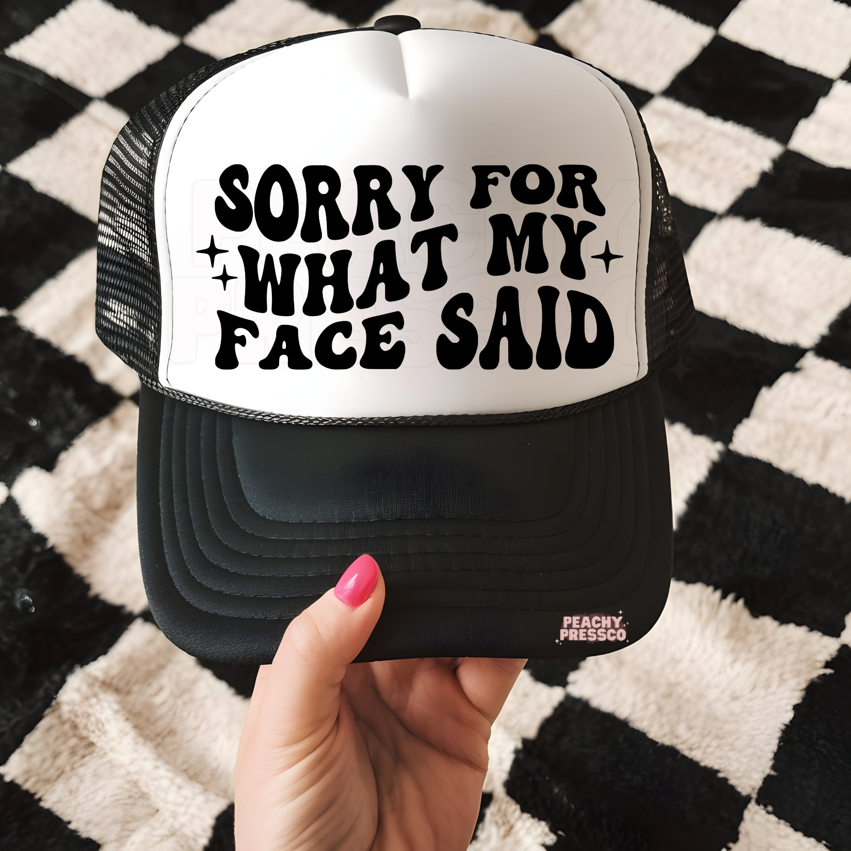 Black and white trucker hat with bold “Sorry For What My Face Said” graphic.